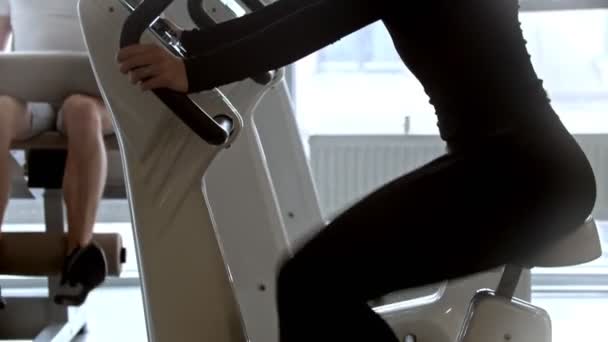 Молодой человек и женщина тренируются в современном белом спортзале с большими панорамными зеркалами — стоковое видео