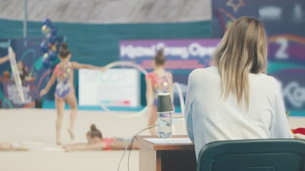 Ritmische gymnastiek toernooi - vrouw rechter kijken naar de prestaties en het geven van een beoordeling — Stockvideo