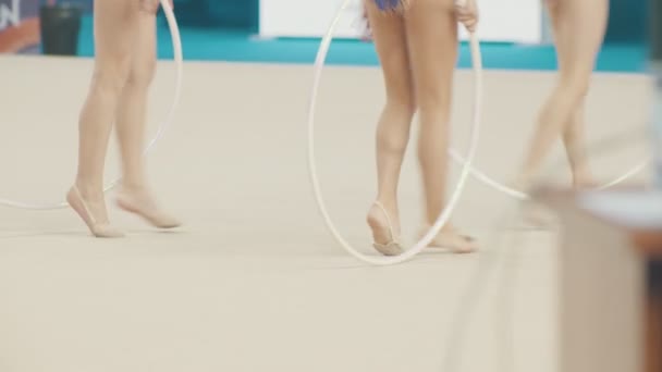 Jonge vrouwen benen op de ritmische gymnastiek toernooien - lopen op het podium houden hoepels — Stockvideo