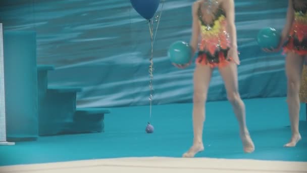 Genç kadın bacakları, ritmik jimnastik turnuvasında sahnede top tutarak yürüyor. — Stok video