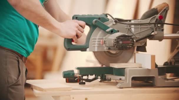 Trabajos de carpintería - hombre cortando la pieza de madera usando una gran sierra circular — Vídeo de stock