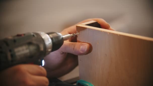 Trabalho de carpintaria - homem trabalhador brocas parafusos na madeira compensada — Vídeo de Stock