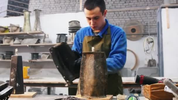 Workshop de concreto - um homem colocando um molde em um produto de concreto — Vídeo de Stock