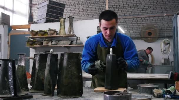 Бетонный цех - мастер вытирания черного бетонного объекта, с которым он работает — стоковое видео