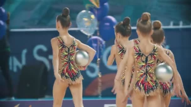 RÚSSIA, KAZAN 12-03-2020, Kazan Stars Open: Jovens mulheres em trajes coloridos saindo do palco do torneio de ginástica rítmica e segurando bolas — Vídeo de Stock