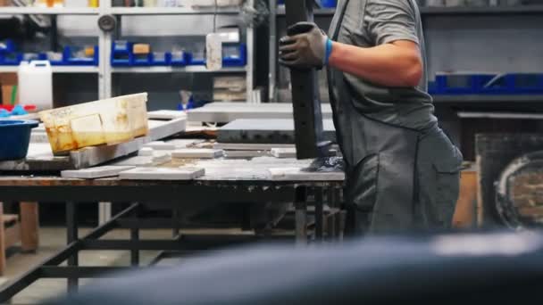 Бетонная мастерская - крепкий мужчина кладет бетонную плиту на рабочий стол — стоковое видео