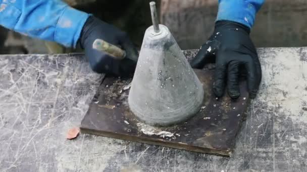 Beton atölyesi. Bitmiş bir beton ürünü işleyen bir adam. — Stok video