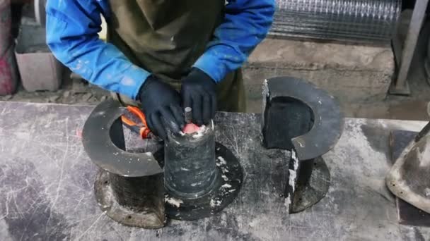 Beton műhely - egy ember egy spatulával eltávolítja a maradványait szárított beton — Stock videók