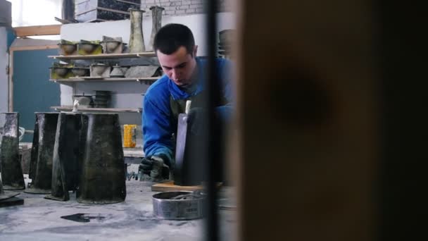 Oficina de concreto - um homem de terno azul limpando objeto de concreto preto — Vídeo de Stock