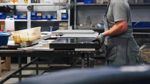 Бетонная промышленность - сильный человек кладет бетонную плиту на рабочий стол — стоковое фото