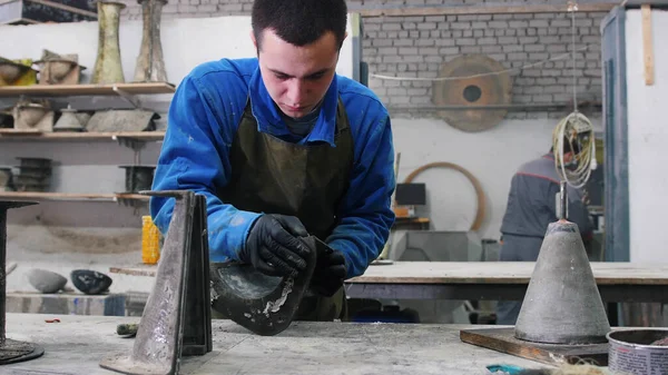 Concrete workshop - young man is cleaning concrete pouring mold — Stock Photo, Image