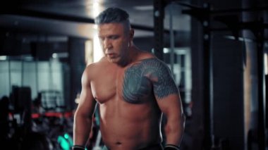 Omuzunda dayanıklılık egzersizi yapan güçlü bir vücut geliştirme ustası.