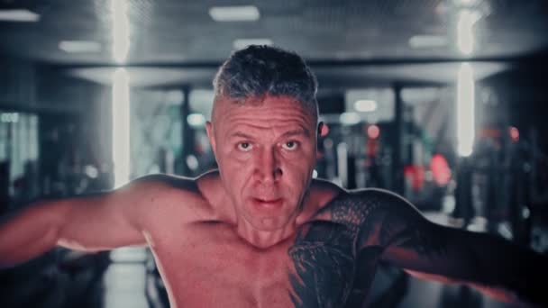 Uomo duro con i capelli grigi che allena le mani in palestra — Video Stock