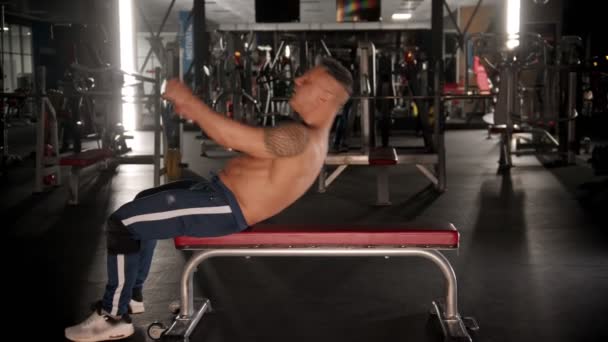 Yetişkin bir vücut geliştirici egzersiz yapmaya hazırlanıyor, bankta yatıyor. — Stok video