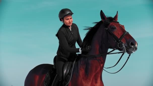 Jízda na koni - jezdec sedící na hřbetním koni s černou hřívou a hladící ji