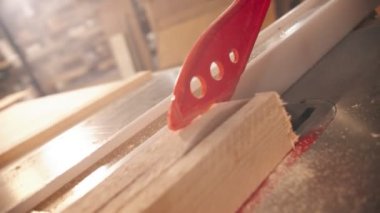 Dairesel testerenin altındaki tahta tahtayı plastik bir sopayla itiyorum.