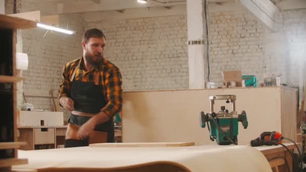 Industria de carpintería - hombre cortando una pequeña pieza de madera usando una gran sierra circular — Vídeos de Stock