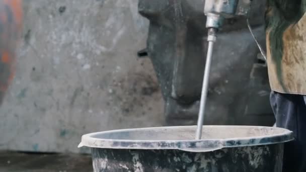 Concrete workshop - the master mixing the concrete mixture with a huge screw — Stock Video