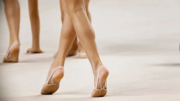 参加体操节拍比赛的年轻女子双腿穿着尖皮鞋站在舞台上 — 图库照片