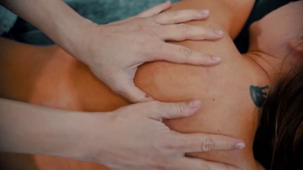 Massaggio - massaggiatrice sta impastando la pelle abbronzata sulla schiena del cliente con le dita — Video Stock