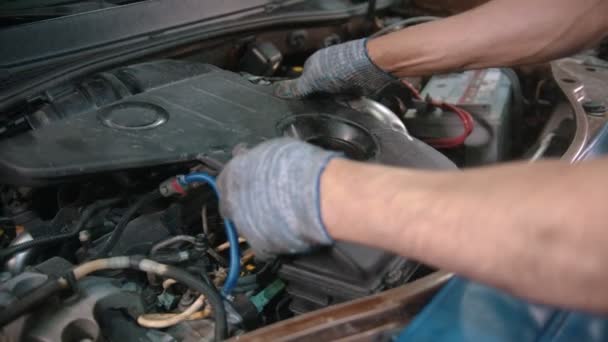 Auto κατάστημα επισκευής - άνθρωπος εργαζόμενος αφαιρεί το κάλυμμα του κινητήρα κάτω από το καπό του αυτοκινήτου — Αρχείο Βίντεο