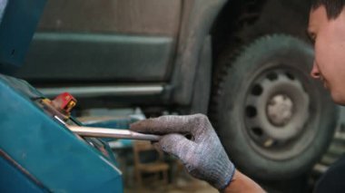 Otomobil tamirhanesi - tamirden sonra arabayı kaldıran genç bir işçi
