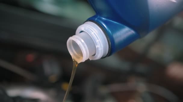 Auto reparatiewerkplaats - man werknemer gieten van nieuwe motorolie met behulp van een trechter — Stockvideo