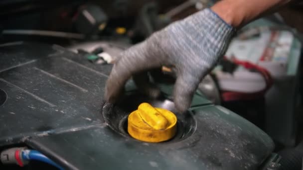 Auto reparatiewerkplaats - man werknemer controleren van de motorolie conditie — Stockvideo