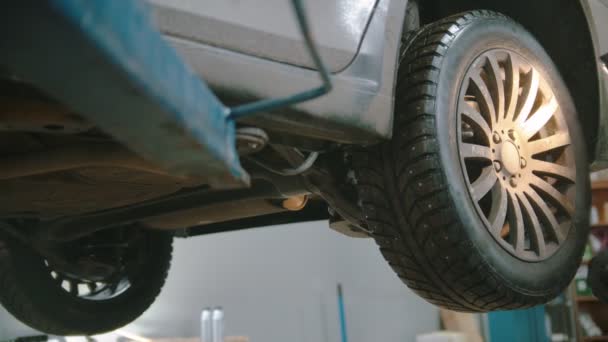 Auto reparation verkstad - man arbetare kommer till en bil som håller en ficklampa — Stockvideo