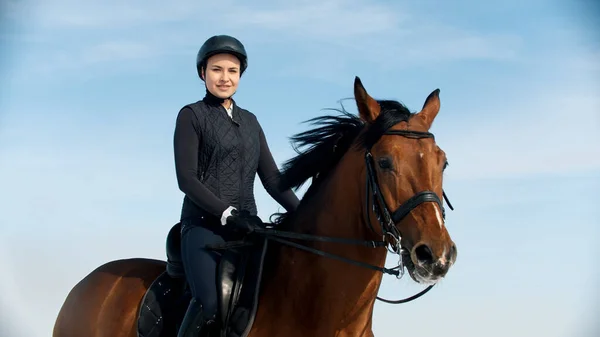 Riding a horse - woman equestrian riding a horse on a snowy field — Stock Photo, Image