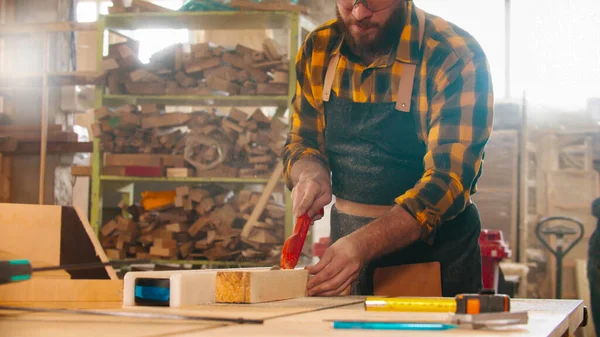 Hombre barbudo cortando un trozo de madera con una sierra circular — Foto de Stock