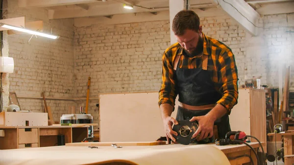 大工業-テーブルの上に研削盤を設置する男の労働者 — ストック写真