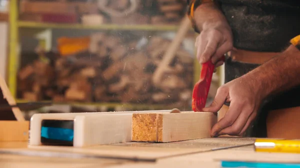 Pushing the wooden part under the circular saw using a plastic stick — Stock Photo, Image