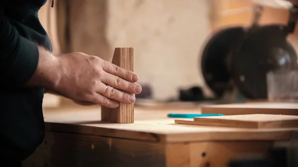 Trabajos de carpintería - hombre sosteniendo piezas planas de detalles de madera en el taller — Foto de Stock