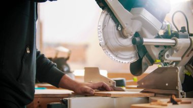 Marangozluk işi - kontrplağı dairesel testere kullanarak kesmek üzere olan işçiler