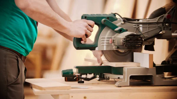 Industria de carpintería - hombre cortando la pieza de madera usando una gran sierra circular — Foto de Stock