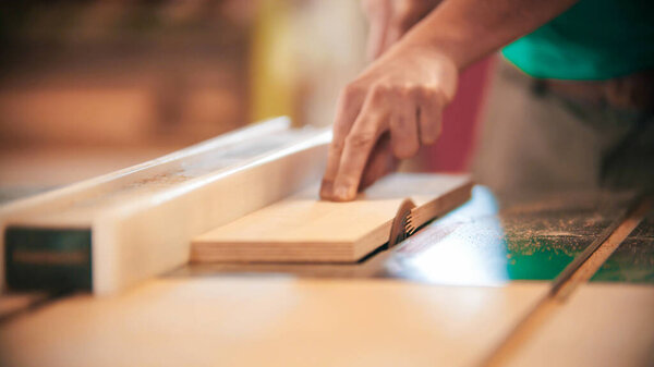 Carpentry industry - cutting out the piece of wood using a small circular saw