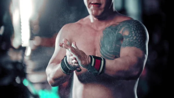 Un bodybuilder uomo che si copre le mani con il talco — Foto Stock