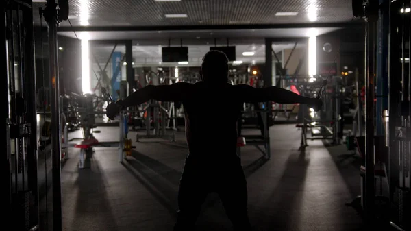 Silhouette of tough man training in the gym — Stock Photo, Image