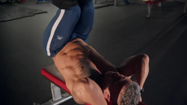 Un uomo adulto bodybuilder formazione in palestra sdraiato sulla panchina — Foto Stock