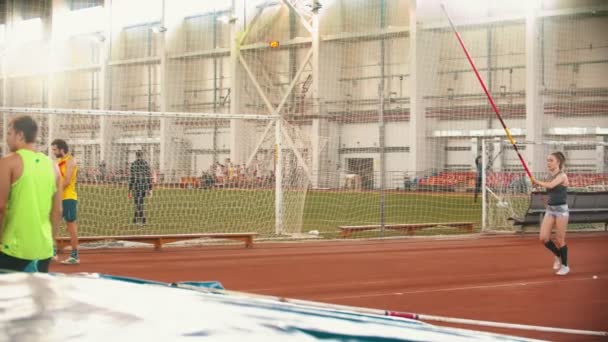 Jovens no salto com vara treinando no estádio dentro de casa — Vídeo de Stock