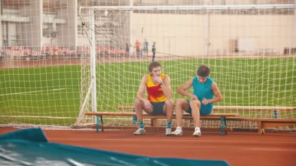 Due uomini seduti sulla panchina mentre l'allenamento della volta a palo — Video Stock