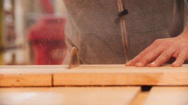 Atölyedeki büyük dairesel testereyle tahtayı ikiye bölmek.