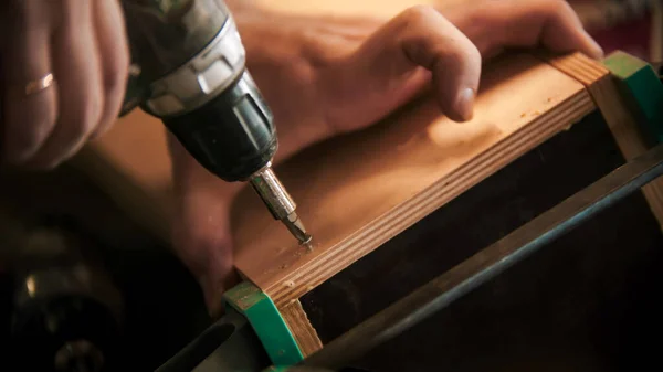 Trabajos de carpintería - taladros de trabajo tornillos en la pieza de madera contrachapada — Foto de Stock