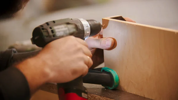 Carpintería - trabajador taladra agujeros en la madera contrachapada — Foto de Stock