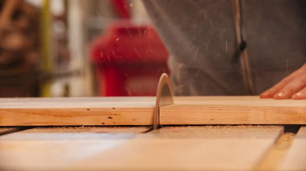 Corte a madeira ao meio usando uma serra circular na oficina — Fotografia de Stock
