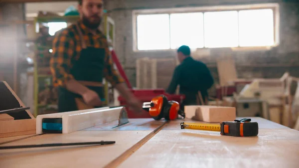 Hombres que trabajan en el taller de carpintería - diferentes artículos sobre la mesa — Foto de Stock