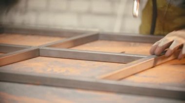 Metal kirişler arasındaki dikişleri kaynak yapan bir işçi.