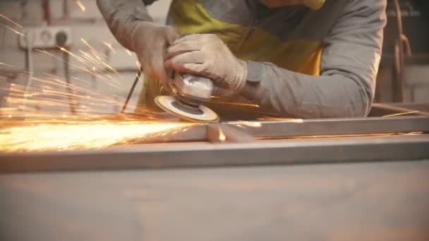 Slijpen van de naden van een ijzeren frame in de laswerkplaats — Stockvideo