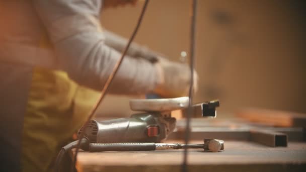 Um homem trabalhador fazendo marca no feixe de metal e prestes a cortá-lo com um moedor — Vídeo de Stock